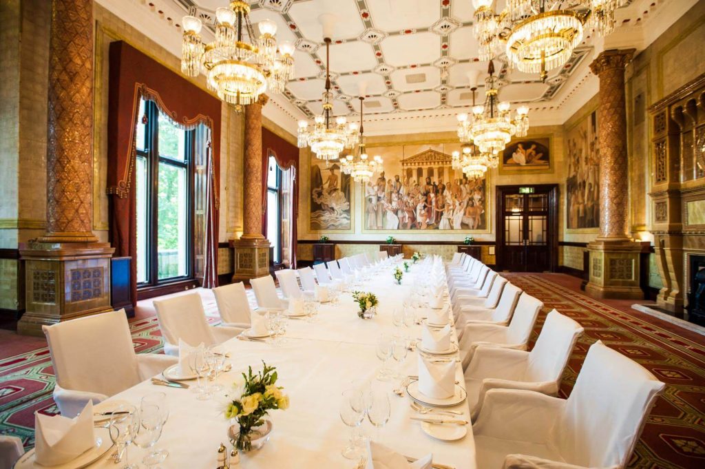 elegant room with a long table columns and crystal chandeliers
