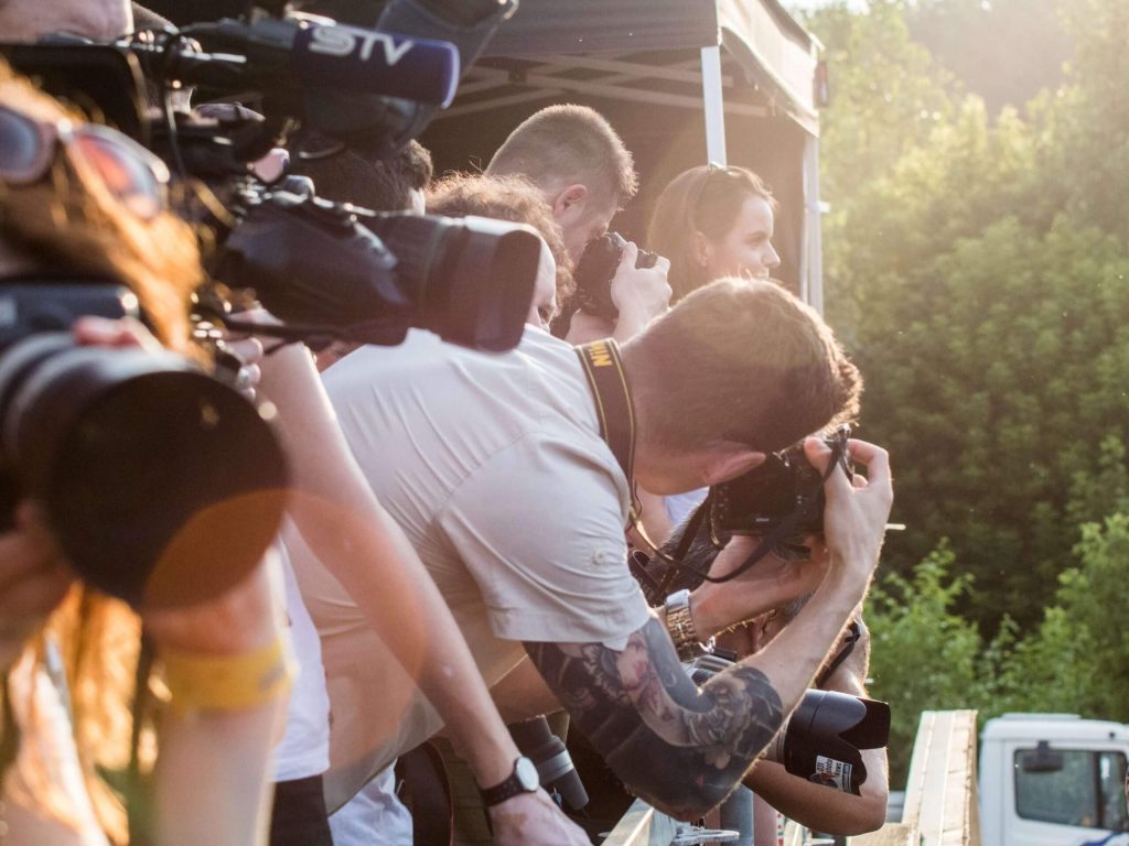 a group of photographers taking pictures in the sun